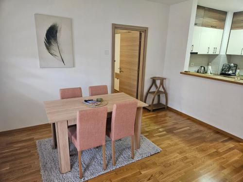 uma sala de jantar com uma mesa de madeira e cadeiras em REA em Pasuljište