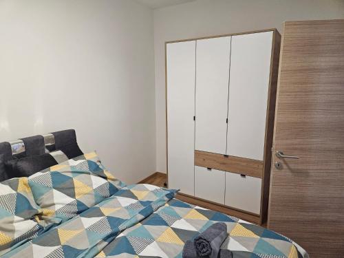 um quarto com uma cama e um armário branco em REA em Pasuljište