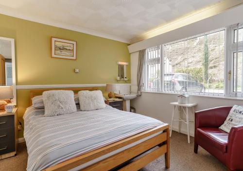 サンダースフットにある2 Strandwaysのベッドルーム1室(ベッド1台、椅子、窓付)