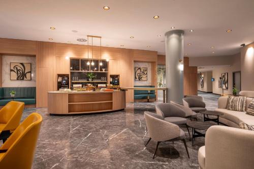 a lobby of a hotel with a counter and chairs at Brussels Marriott Hotel Grand Place in Brussels