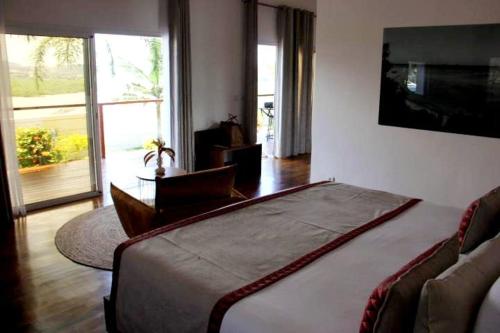 a bedroom with a large bed and a television at Andriana Resort & Spa in Nosy Be