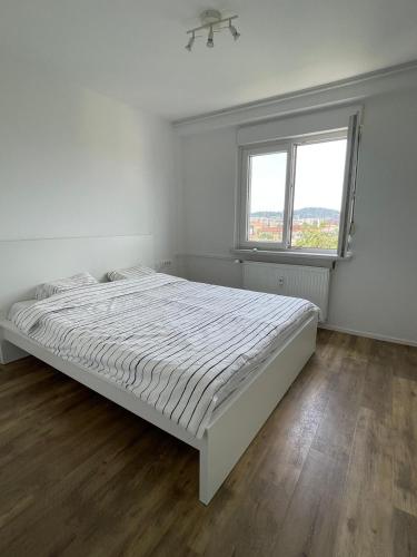 - une chambre blanche avec un lit et une fenêtre dans l'établissement Martin’s flat in the city centre, à Ljubljana