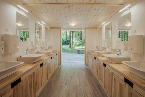 a bathroom with a row of sinks and mirrors at Forest Camping Mozirje in Mozirje