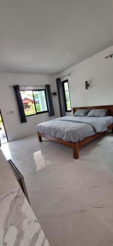 1 dormitorio con 1 cama grande y 2 ventanas en IBIZA BEACH Resort, en Haad Yao