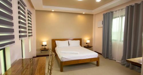 a small bedroom with a bed and two lamps at Dancels Inn in Ormoc