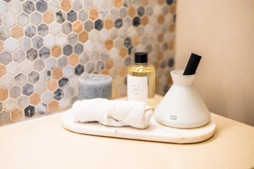 een badkamerbar met een fles parfum en handdoeken bij Voyage 2 Bedroom In Mayan With Ocean Views in Abu Dhabi