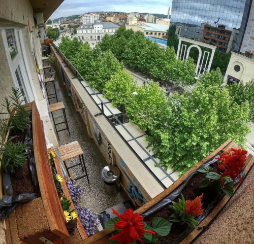 un balcón con flores y plantas en un edificio en Prishtina Center Hostel, en Pristina