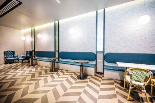 a waiting room with blue chairs and tables at Mercure Singapore Tyrwhitt in Singapore