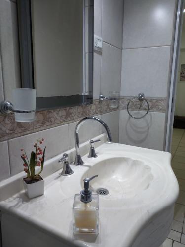 a bathroom sink with a soap dispenser and a mirror at Patagonia Relax in Comodoro Rivadavia