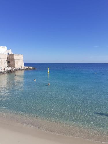a person standing in the water at the beach at Carpe Diem B&B e Case Vacanza in Monopoli