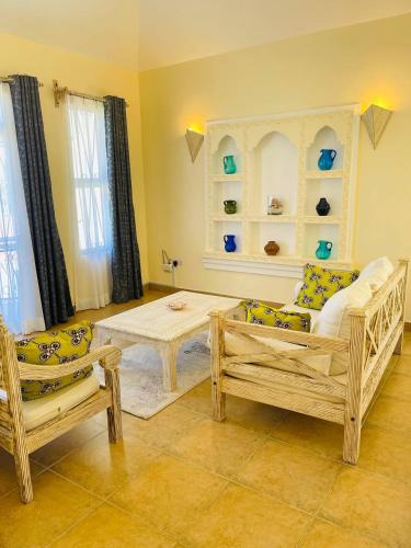 a living room with two chairs and a table at Villa Macheo in Mombasa