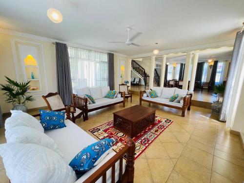 ein großes Wohnzimmer mit Sofas und einem Tisch in der Unterkunft Villa Macheo in Mombasa