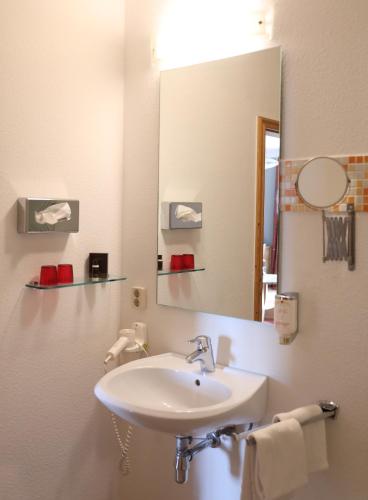 a bathroom with a sink and a mirror at Kulturhotel Kaiserhof in Bad Liebenstein