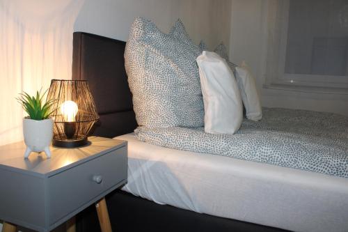 a bedroom with a bed with a lamp and a nightstand at Ruhiges & schickes 4 Zi-Apartment in Heilbronn