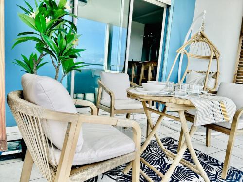 a room with a rattan table and chairs at Perle insulaire in Saint-Denis