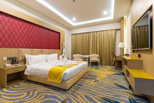 a hotel room with a bed and a flat screen tv at Hotel Mechi Crown, Jhapa in Kakarvitta