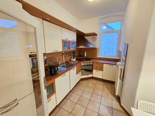 a small kitchen with white cabinets and a window at Zagreb Central 2BR + Parking in Zagreb