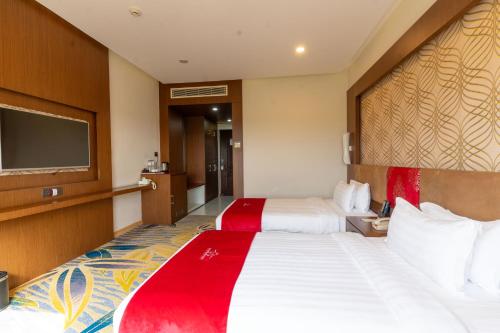 a hotel room with two beds and a flat screen tv at Hotel Mechi Crown, Jhapa in Kakarvitta