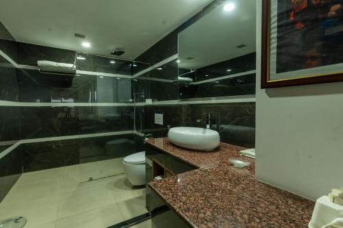a bathroom with a sink and a toilet at Hotel Mechi Crown, Jhapa in Kakarvitta