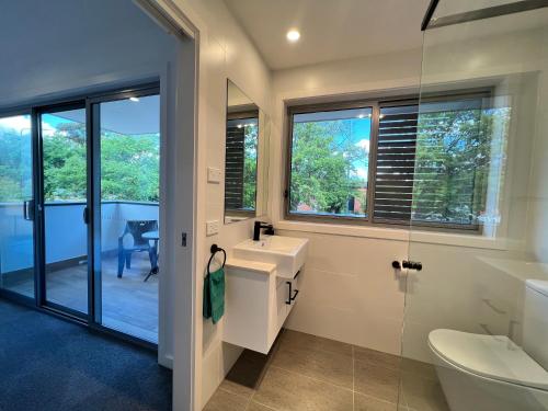 La salle de bains est pourvue d'un lavabo, de toilettes et de fenêtres. dans l'établissement Stunning Dickson Luxe 3BR 2Bath Double Garage WiFi Brand New Home, à Canberra