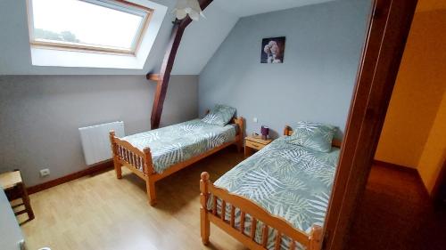 une petite chambre avec deux lits et une fenêtre dans l'établissement Gite LA ROCHERIE, à Hambers