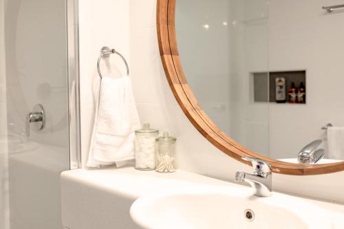een badkamer met een wastafel en een spiegel bij Caloundra Poolside Paradise in Caloundra