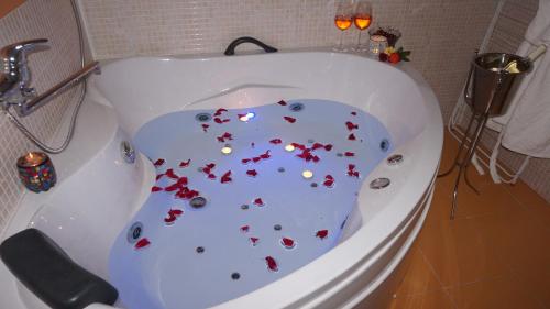 a white tub with red hearts on the floor at Хотел Стиляна/Hotel Stilyana in Devin