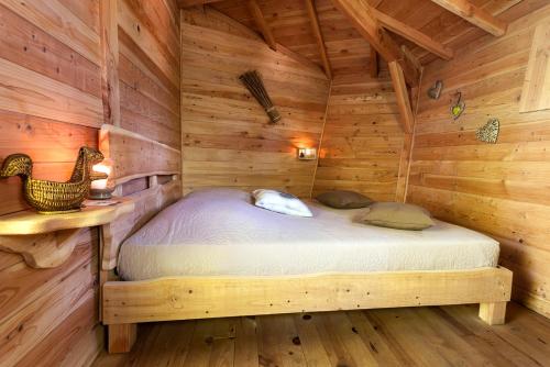 a bedroom of a log cabin with a bed in it at Les Cabanes de Fontfroide in Saint-Antoine