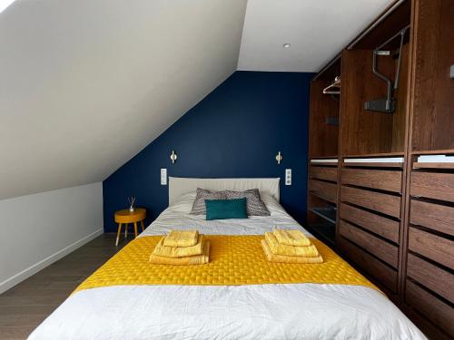 a bedroom with a large bed with yellow and blue walls at Appartement à 10 min d’Orly in Athis-Mons