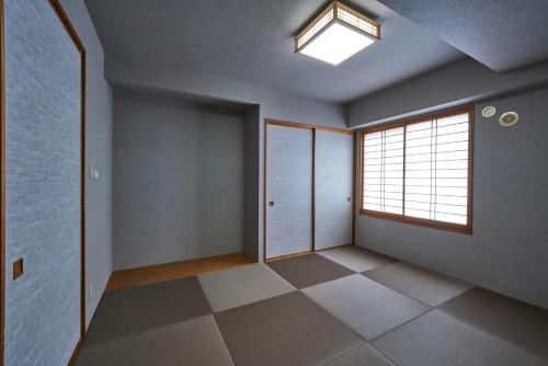 an empty room with a window and a door at Hotel Village Izukogen in Ito