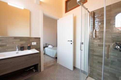 uma casa de banho com um lavatório e uma cabina de duche em vidro. em Mamo Florence - Pilastri Terrace em Florença
