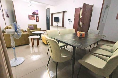 a living room with a table and chairs and a room at Les Alizés Appartement meublé 2 in Toamasina