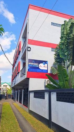 un edificio con un cartello sul lato di Les Alizés Appartement meublé 2 a Toamasina