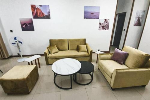 un soggiorno con 2 divani e un tavolo di Les Alizés Appartement meublé 2 a Toamasina