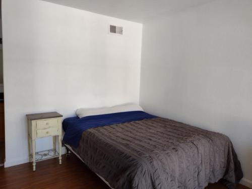 um pequeno quarto com uma cama e uma mesa de cabeceira em Spacious Pleasanton Home, 4br-2ba, Kitchen, WiFi, Laundry, Parking and More em Pleasanton
