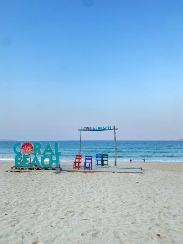 a beach with a sign on the sand and the ocean at THE SEA at THE ARINA CAM RANH in Thôn Hò Ða