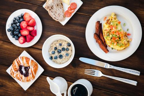 a wooden table with plates of breakfast food on it at Omni Corpus Christi Hotel in Corpus Christi