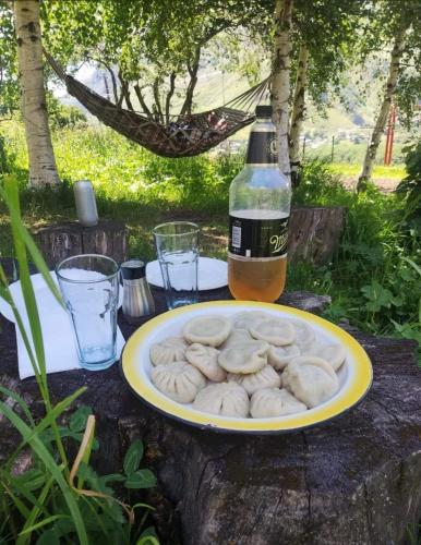 a plate of food on a table with a bottle of beer at Emotion Kazbegi in Stepantsminda