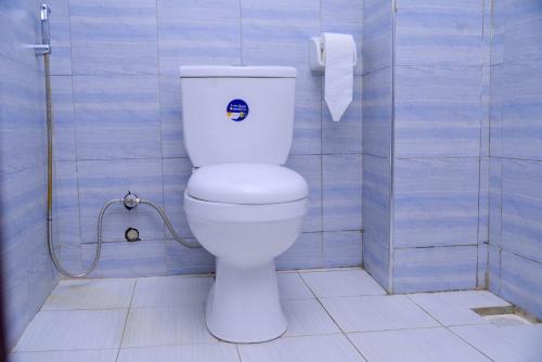 a bathroom with a white toilet in a blue wall at 3 Bedroom Malaikanzi Apartment in Namulanda