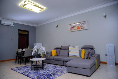 a living room with a couch and a table at 3 Bedroom Malaikanzi Apartment in Namulanda