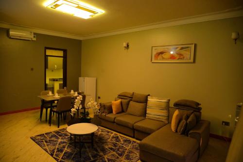 a living room with a couch and a table at 3 Bedroom Malaikanzi Apartment in Namulanda