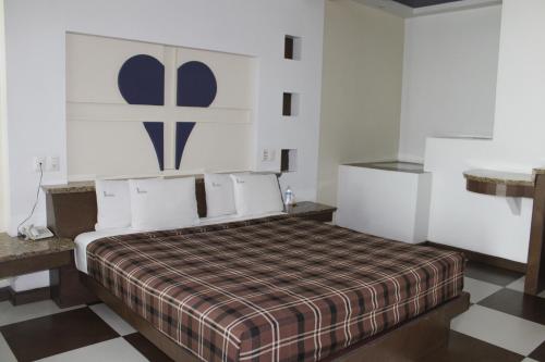 a bedroom with a bed with a checkered floor at Motel Dubái Ensenada in Ensenada