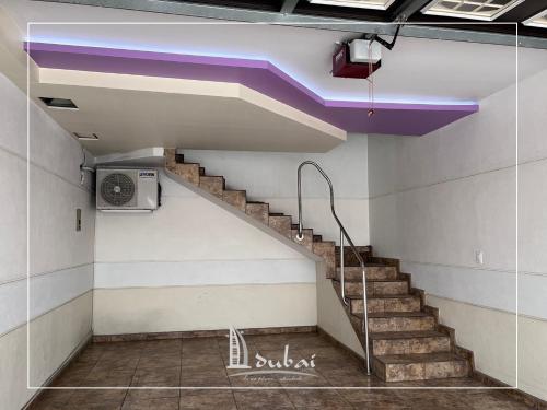 Un escalier se trouve dans un bâtiment doté d'un plafond violet. dans l'établissement Motel Dubái Ensenada, à Ensenada
