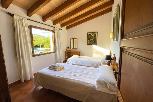 Un dormitorio con dos camas y una ventana. en Villa Cal Roma, en Pollensa