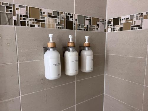 eine Gruppe von drei Flaschen an einer Wand in einem Badezimmer in der Unterkunft Arion- Cozy Santa Monica getaway steps to the beach Free Parking in Los Angeles