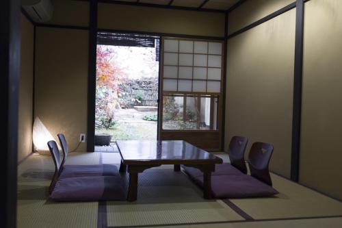 a dining room with a table and chairs and a window at Shirafuji-an Modern Private Machiya in Central Kyoto in Kyoto