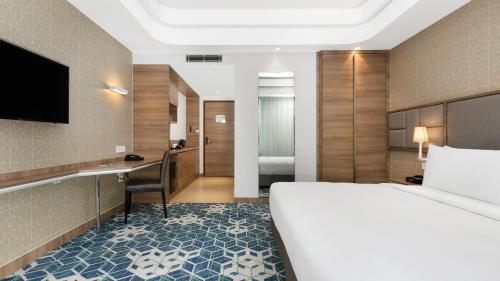 a hotel room with a bed and a desk at Holiday Inn Gurugram Sector 90 by IHG in Gurgaon