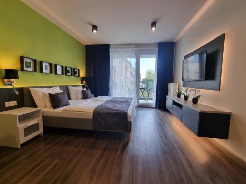 RiverCity Apartments في بودابست: غرفة نوم بسرير وتلفزيون بشاشة مسطحة