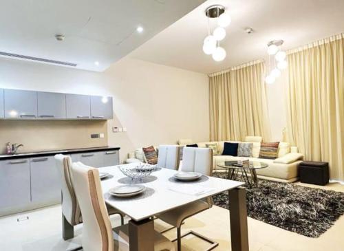 Bandar Jişşah的住宿－Cozy room near pool muscat Bay，厨房以及带桌子和沙发的客厅。