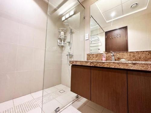 ein Bad mit einer Dusche, einem Waschbecken und einem Spiegel in der Unterkunft Cozy room near pool muscat Bay in Bandar Jişşah
